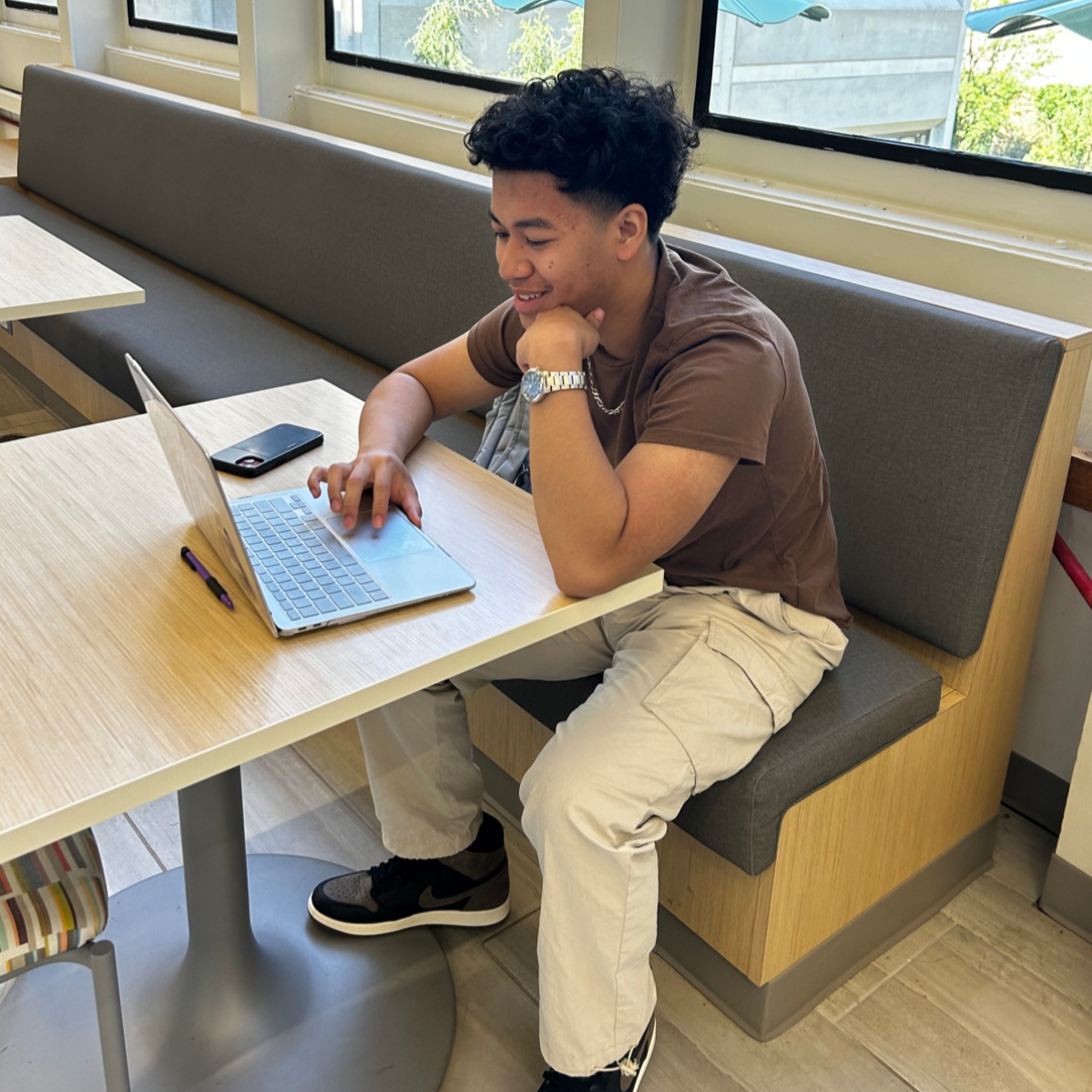 Male student sitting at a table on computer