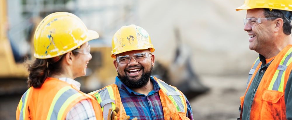 three construction workers smiling in a group