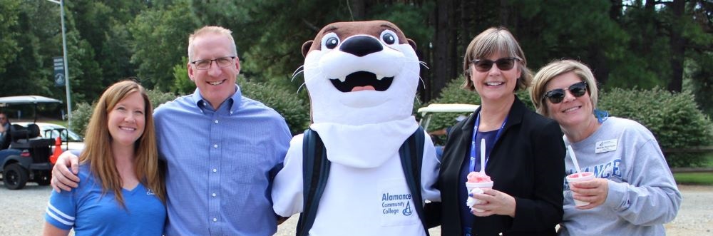 haw the otter standing with faculty and staff members of ACC